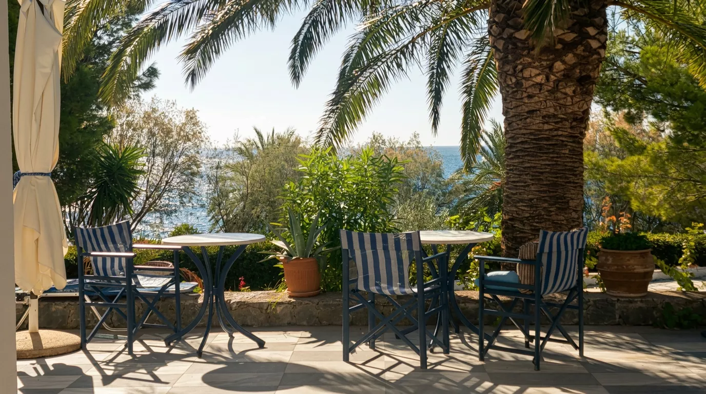 Terrasse mit blauen Stühlen und Meerblick unter Palmen